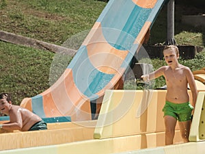 Kids having fun riding water slides on summer vacation