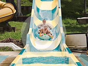 Kids having fun riding water slides on summer vacation