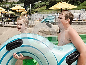 Kids having fun riding water slides on summer vacation