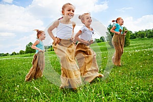 Kids having fun with sacks on a meadow