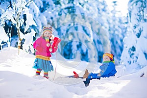 Kids having fun on a sleigh ride in snow
