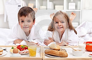 Kids having a healthy breakfast in bed