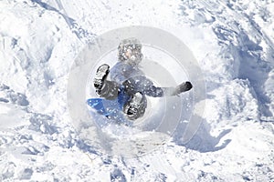 Kids having a lot of fun in the snow sledding