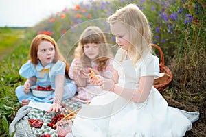 Kids having picnic outdoors. Playing children at summer day