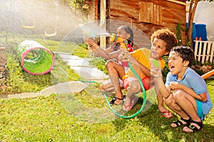 Kids hide and shoot with water guns in fun game