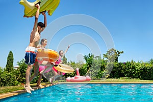 Kids hold inflatable toys dive into the water pool