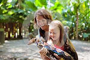 Kids hold python snake at zoo. Child and reptile