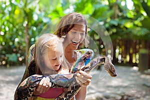 Kids hold python snake at zoo. Child and reptile