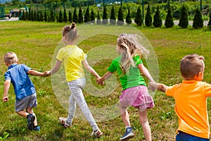 Kids holding hands and running, having fun outdoors