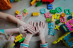 Kids holding hands together in playroom, friendship concept