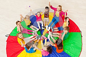 Kids holding hands together with teacher in gym