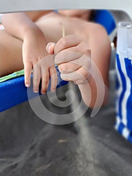 Kids holding sand in its hand. Child on the Beach holding Sand.
