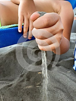 Kids holding sand in its hand. Child on the Beach holding Sand.