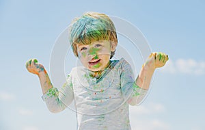 Kids Holi festival. Painted face of funny kid. Festival of colors. Little boy plays with colors.