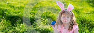 Kids hunting easter eggs. easter basket Boy with easter eggs and bunny ears in backyard. Horizontal photo banner for