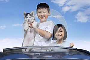 Kids and husky puppy on the sunroof