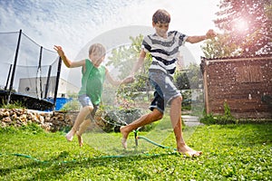 Kids immersed in water game on open air, with sunny backyard