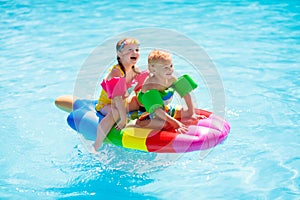 Kids on inflatable float in swimming pool
