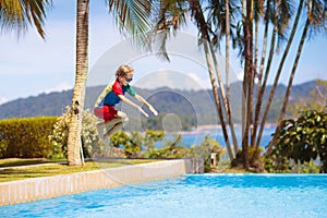 Kids jump into swimming pool. Summer water fun