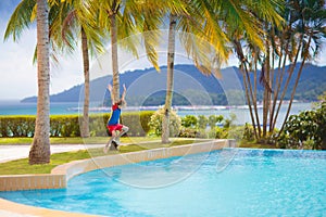 Kids jump into swimming pool. Summer water fun