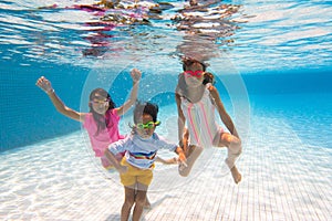 Kids jump into swimming pool. Summer water fun