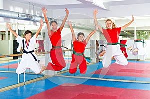 Kids and karate trainer jumping in gym