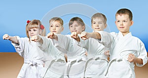 Kids in karategi are hitting punch arm