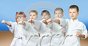 Kids in karategi are hitting punch arm photo