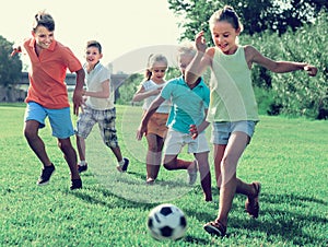 Kids kicking football in park