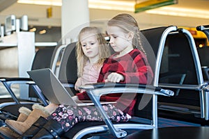 Kids with a laptop at the airport while waiting