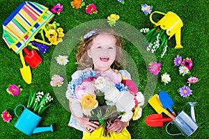 Kids on a lawn with garden tools