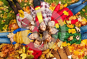 Kids lay on the autumn grass