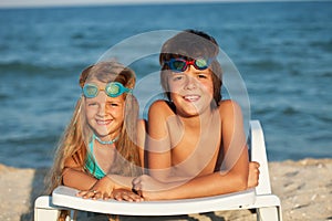Kids laying on beach chair wearing swimming goggles
