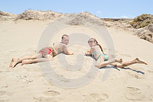 Kids laying on the warm sand