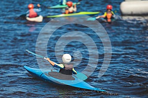 Kids learn kayaking, canoeing whitewater training in the lake river, children practicing paddling, young kayakers in summer camp