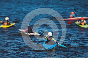 Kids learn kayaking, canoeing whitewater training in the lake river, children practicing paddling, young kayakers in summer camp