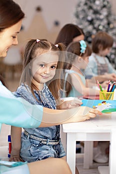 Kids learning arts and crafts in kindergarten with teacher