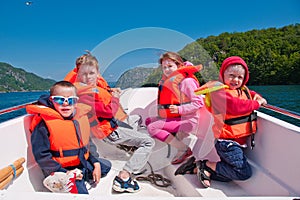 Kids in lifejackets in a boat