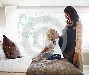 Kids are lifes special little joy. a pregnant woman bonding with her little son at home.