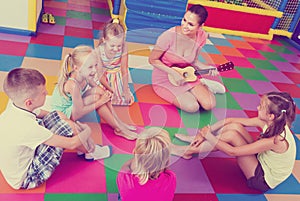 Kids listening teacher playing musician instrument