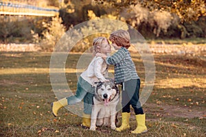 Kids Love story. Smiling little kids with dog walking over autumn field background. Romantic and love. Sweet childhood.