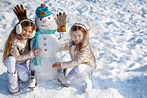 Kids make Snowman on white snow background. Happy children playing with a snowman on a snowy winter walk.