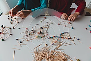 Kids making geometric shapes from sticks and play dough