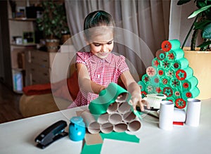 Kids making handmade advent calendar with toilet paper rolls at home. Seasonal activity for kids