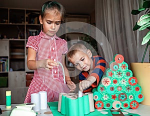 Kids making handmade advent calendar with toilet paper rolls at home. Seasonal activity for kids