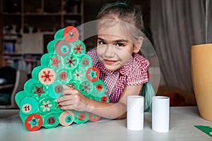 Kids making handmade advent calendar with toilet paper rolls at home. Seasonal activity for kids