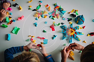 Kids making origami crafts with paper, learning