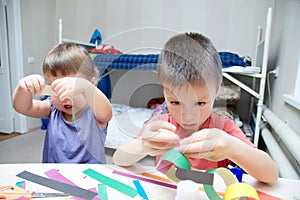 Kids making paper colored garland, siblings craft, brother and s