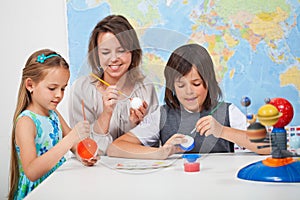 Kids making a scale model of the solar system in science class-