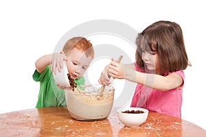 Kids mixing and pouring cake ingredients photo